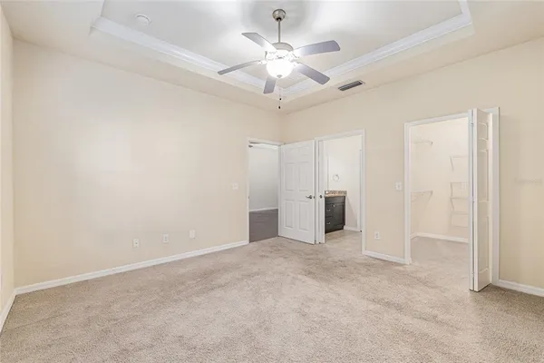 an empty room with fan and entryway