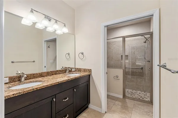 a bathroom with a granite countertop sink shower and a mirror