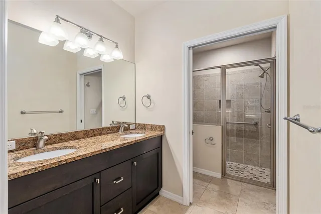 a bathroom with a granite countertop sink shower and a mirror