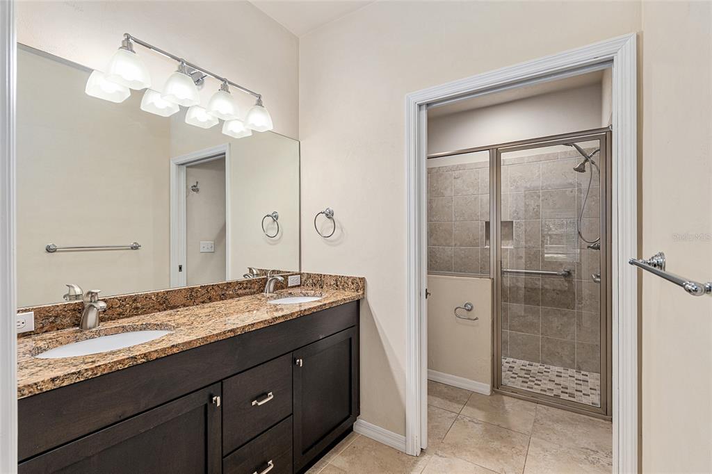 12731 Northwest 12th Road Newberry, FL 32669 - Photo 25 of 33 a bathroom with a granite countertop sink shower and a mirror