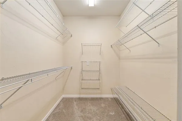 a view of walk in closet with empty racks
