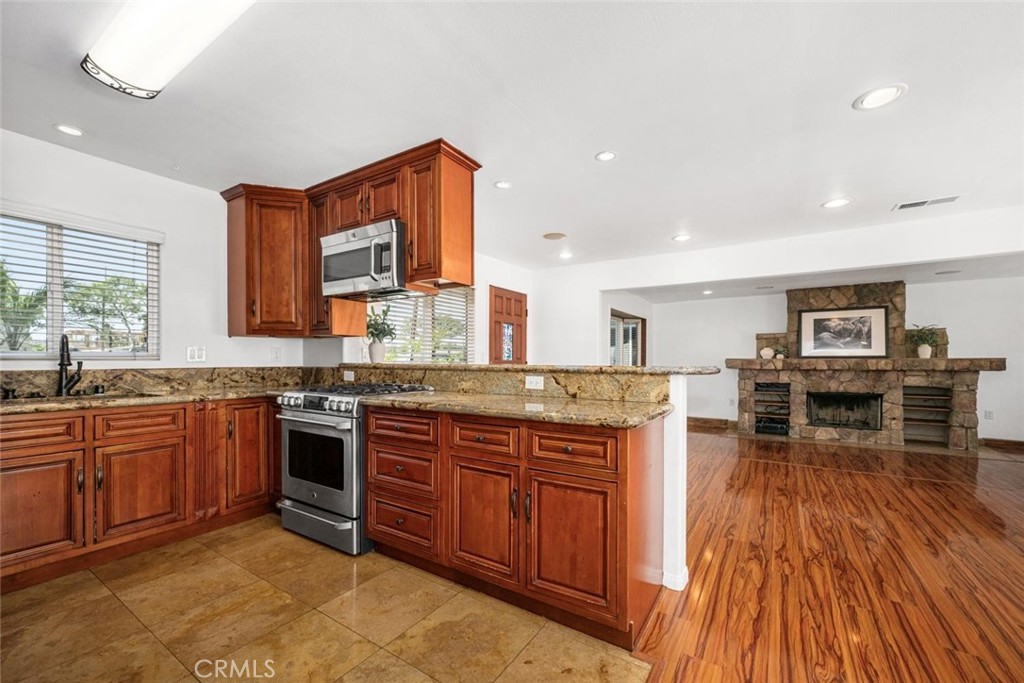 1238 North Studebaker Road Long Beach, CA 90815 - Photo 15 of 47 a kitchen with stainless steel appliances granite countertop wooden floors and view living room