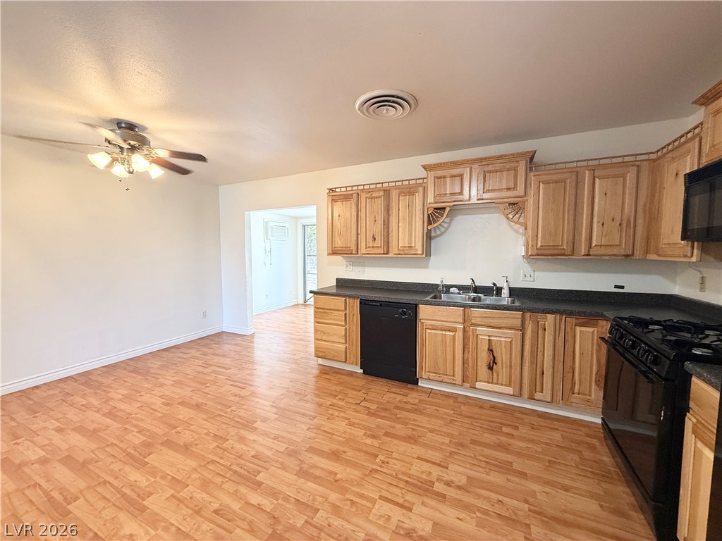 616 Greenway Road Henderson, NV 89002 - Photo 8 of 32 A well-lit kitchen with natural wood cabinetry and resilient flooring awaits culinary creations.