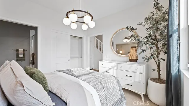 a bedroom with bed and a chandelier
