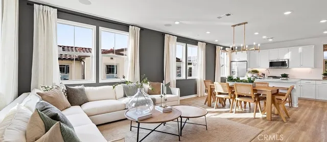 a living room with furniture kitchen and a large window
