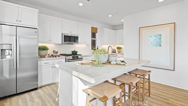 a kitchen with stainless steel appliances granite countertop a refrigerator and a stove top oven