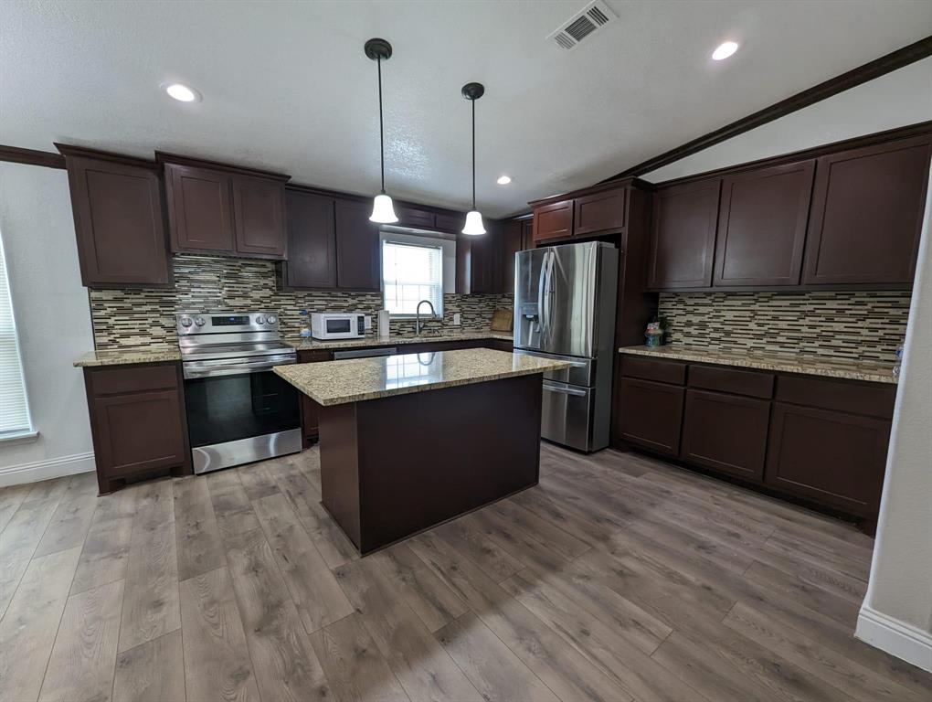701 Rumage Road Jacksboro, TX 76458 - Photo 11 of 15 a kitchen with stainless steel appliances granite countertop a stove a sink dishwasher a refrigerator and a oven with wooden floor