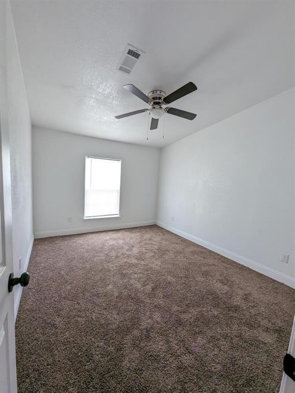 701 Rumage Road Jacksboro, TX 76458 - Photo 4 of 15 an empty room with a ceiling fan and a window