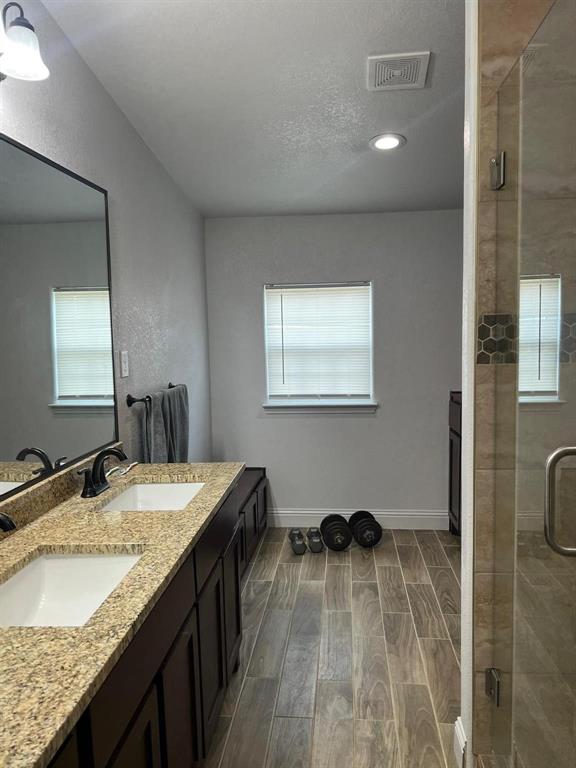 701 Rumage Road Jacksboro, TX 76458 - Photo 7 of 15 a bathroom with a granite countertop sink a mirror and shower