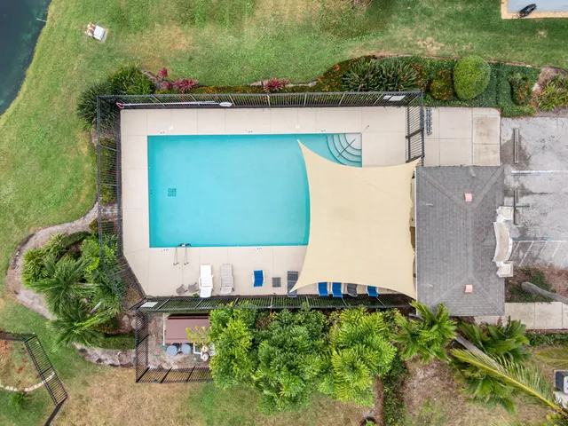an aerial view of a house with a garden and lake view