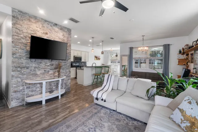 a living room with furniture a flat screen tv and a window