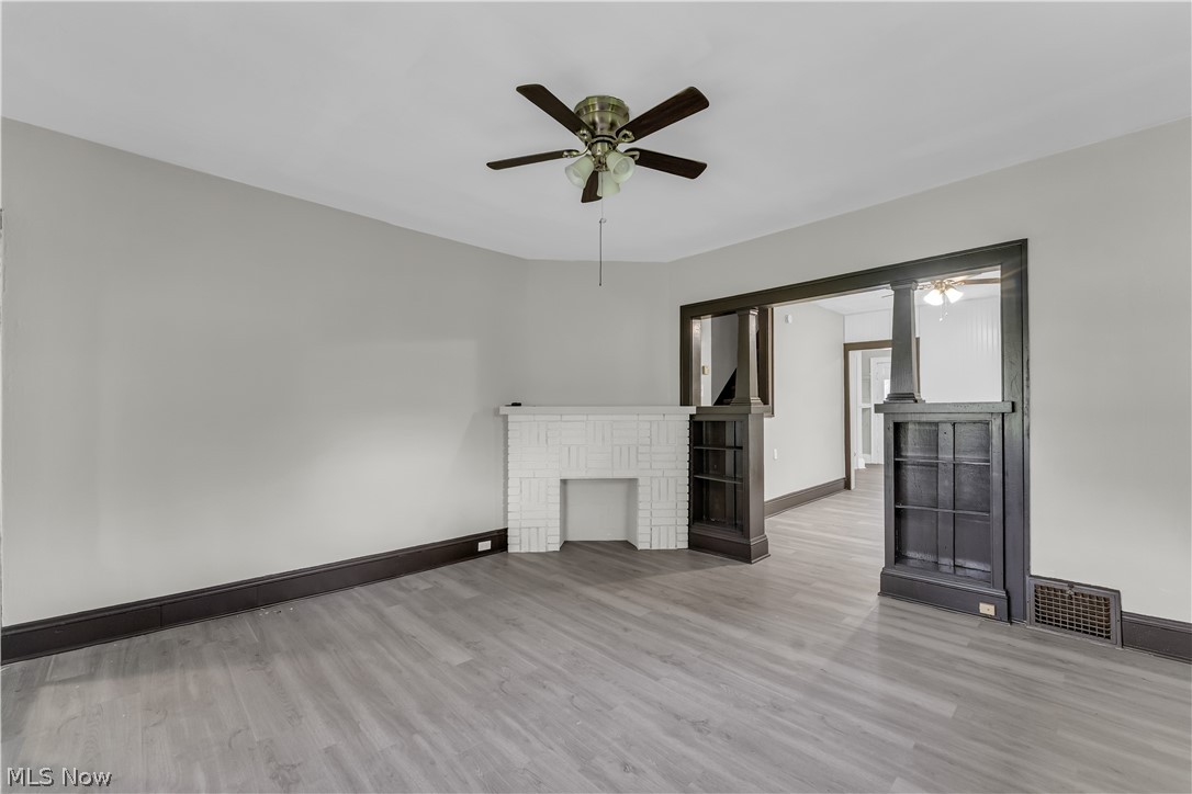 1144 East 145th Street, Unit 1/RIGHT Cleveland, OH 44110 - Photo 6 of 20 Living area featuring light gray wall paint, dark wood-finish trim, and gray wood-finish flooring