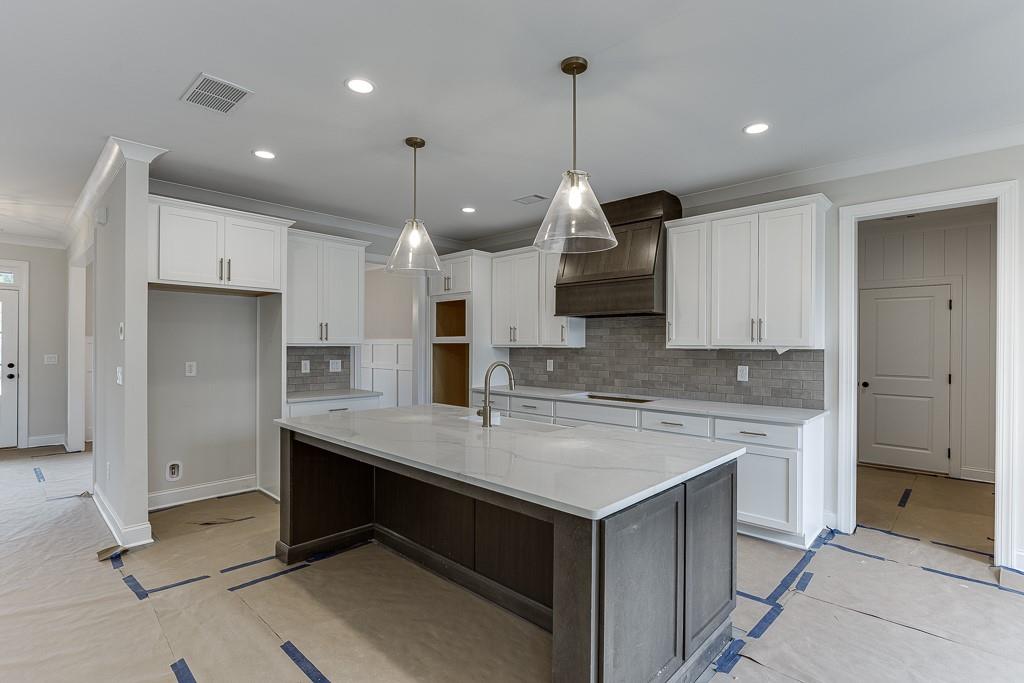 173 Swimming Pool Road Buford, GA 30518 - Photo 13 of 35 a kitchen with kitchen island a counter space a sink appliances and cabinets