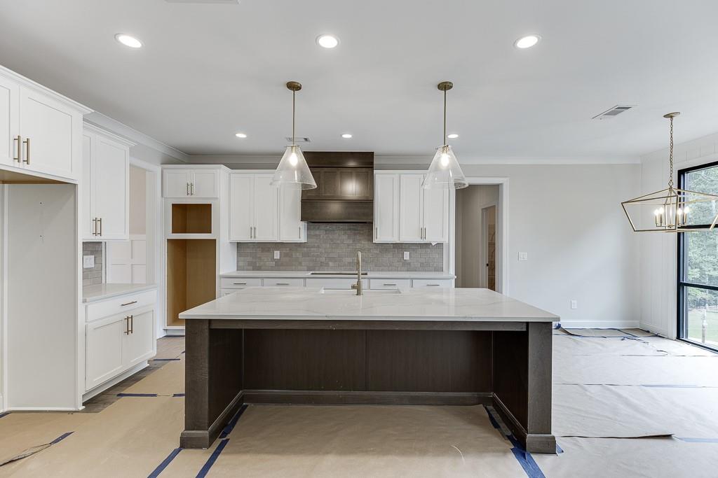 173 Swimming Pool Road Buford, GA 30518 - Photo 14 of 35 a kitchen with kitchen island a sink stainless steel appliances and cabinets