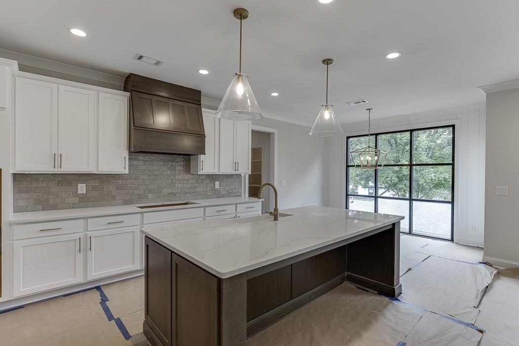 173 Swimming Pool Road Buford, GA 30518 - Photo 15 of 35 a kitchen with a sink center island and cabinets