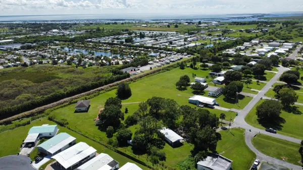 an aerial view of residential houses with outdoor space and trees