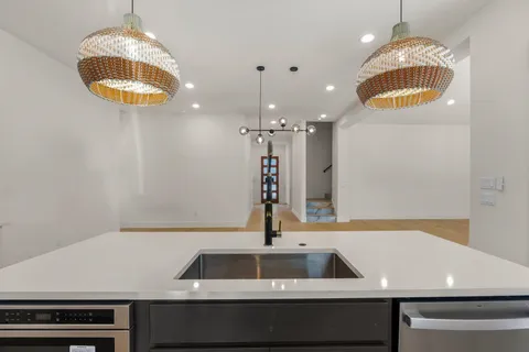 a room with kitchen island a sink and a stove