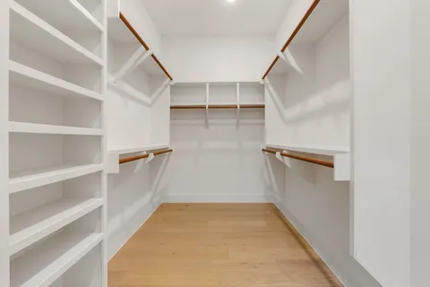a view of walk in closet with empty racks