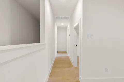 a view of a hallway with wooden floor