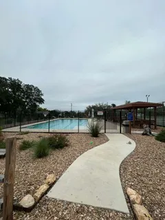 a view of a swimming pool with a patio and a yard