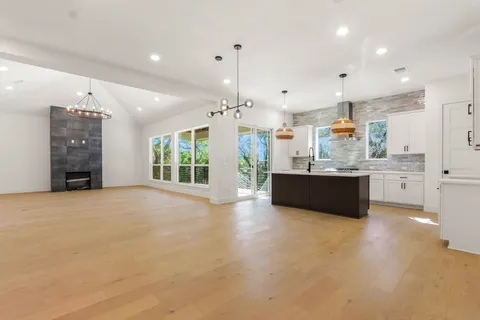 a large kitchen with kitchen island a sink stainless steel appliances and cabinets