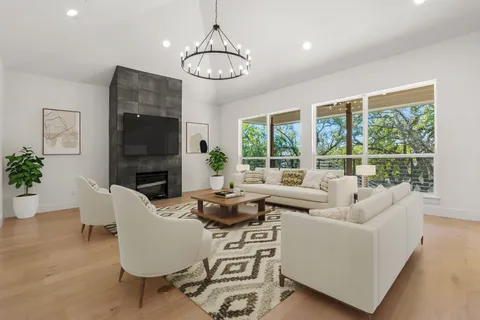 a living room with fireplace furniture and a chandelier