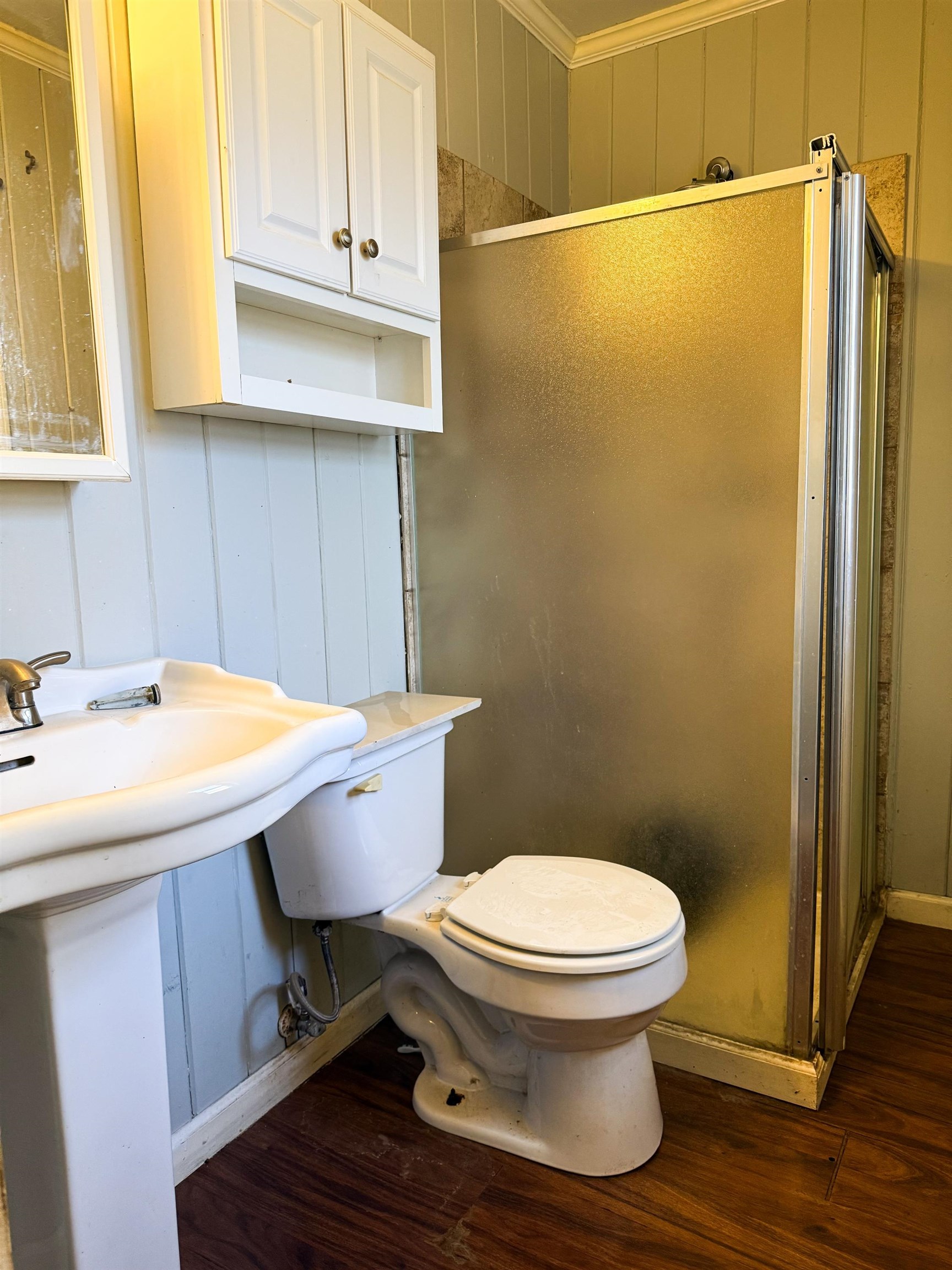 1027 Waring Road Memphis, TN 38122 - Photo 8 of 14 Bathroom with a decorative wall, dark wood finished floors, crown molding, a shower stall, and wood walls