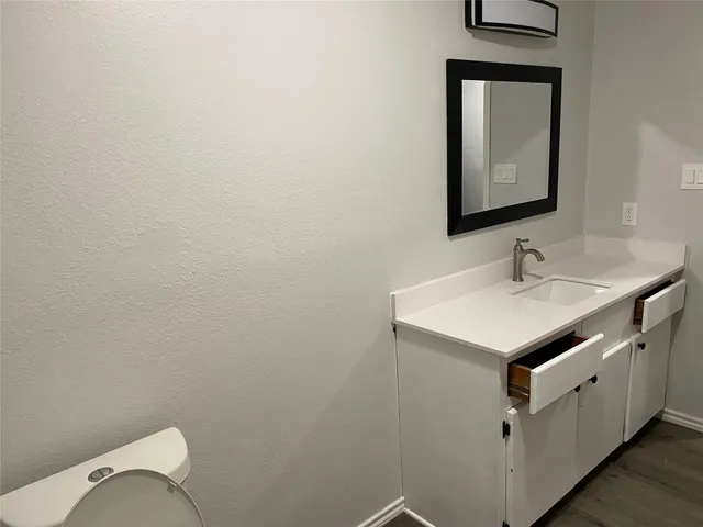a bathroom with a sink toilet and mirror