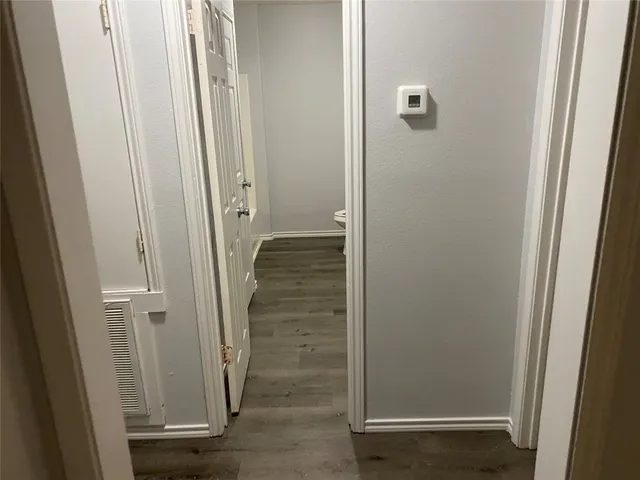 a view of a hallway with wooden floor