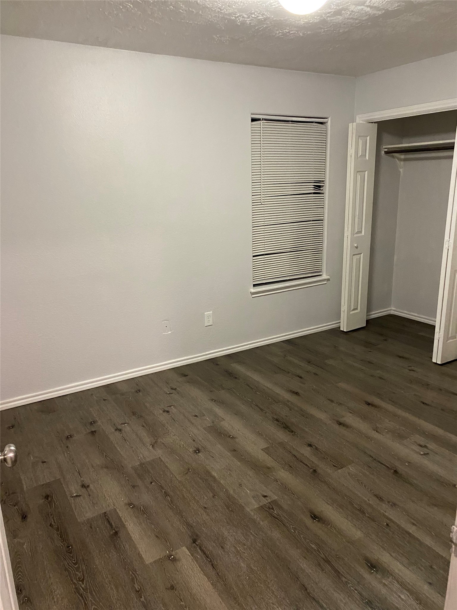 309 South Ave C, Unit A Elgin, TX 78621 - Photo 9 of 15 an empty room with wooden floor closet and windows