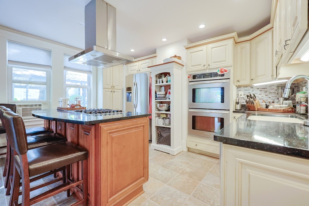 403 Main Street Clinton, MA 01510 - Photo 17 of 42 a kitchen with stainless steel appliances kitchen island granite countertop a stove a sink and a refrigerator
