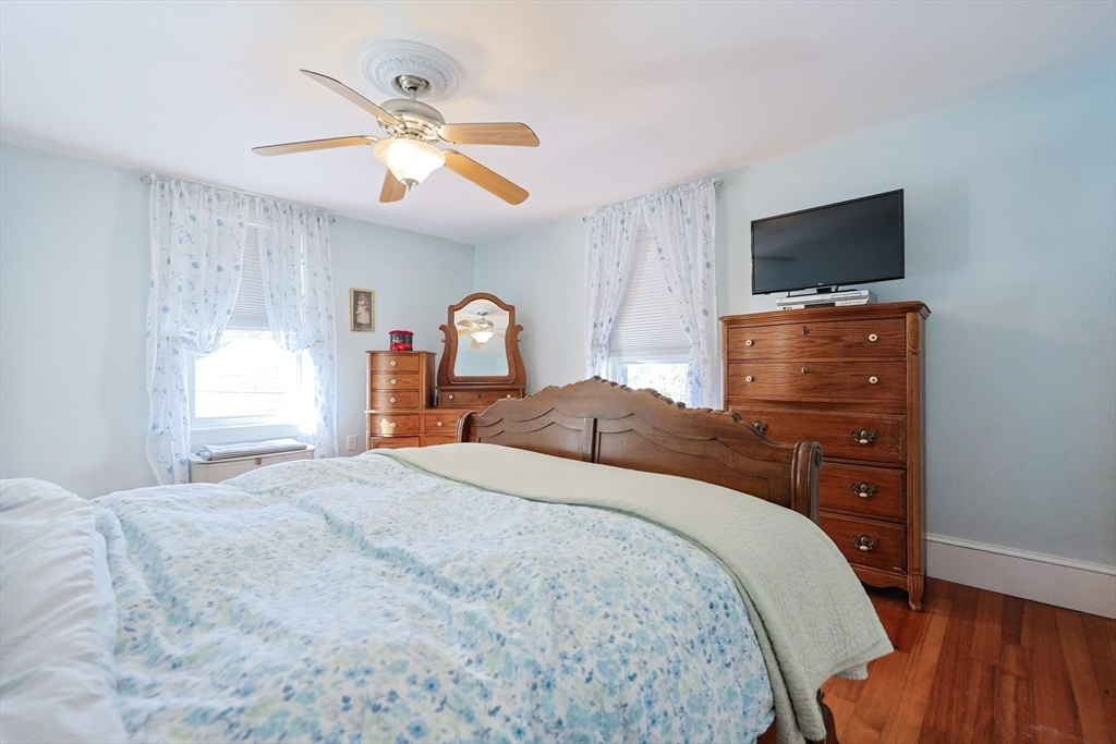403 Main Street Clinton, MA 01510 - Photo 24 of 42 a bedroom with a large bed and a flat tv screen on dresser
