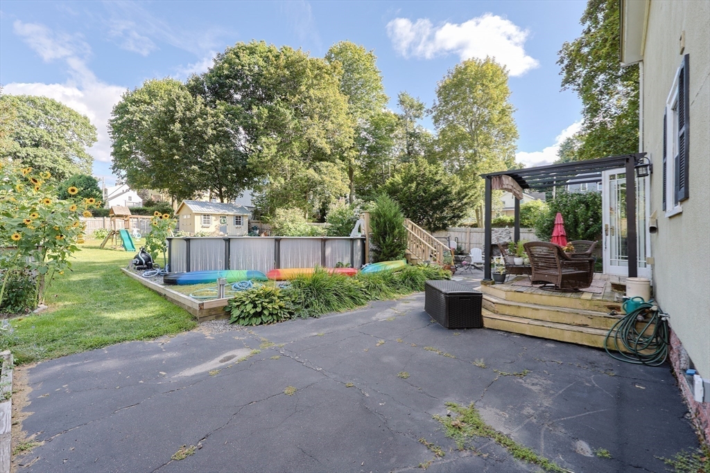 403 Main Street Clinton, MA 01510 - Photo 41 of 42 a view of a patio with table and chairs plants and large trees
