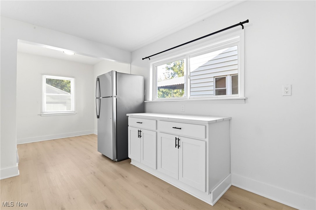 3359 Altamont Road Cleveland, OH 44118 - Photo 6 of 31 Kitchen featuring freestanding refrigerator, white cabinetry, light countertops, and light wood-style flooring