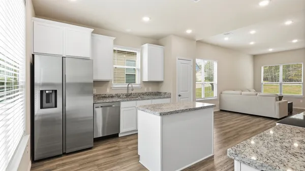 a kitchen with stainless steel appliances granite countertop a refrigerator a sink and a stove