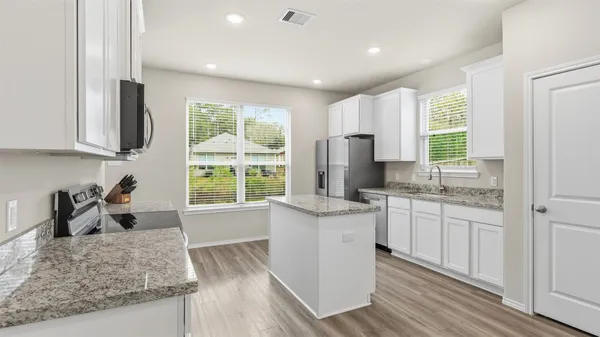 a kitchen with stainless steel appliances granite countertop a stove a sink and a refrigerator