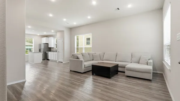 a living room with furniture and a wooden floor