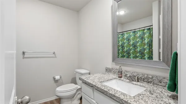 a bathroom with a granite countertop sink a large mirror and a toilet