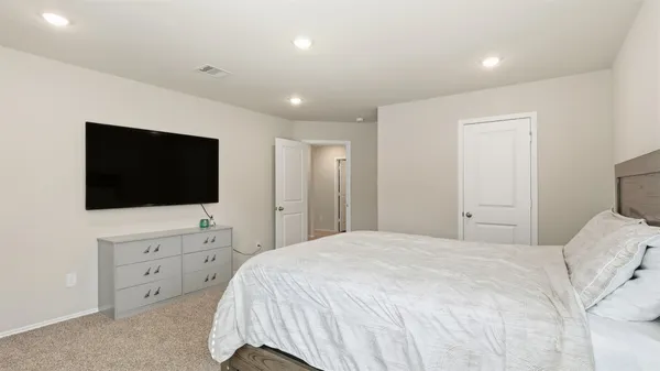 a bedroom with a bed and a flat screen tv in the kitchen
