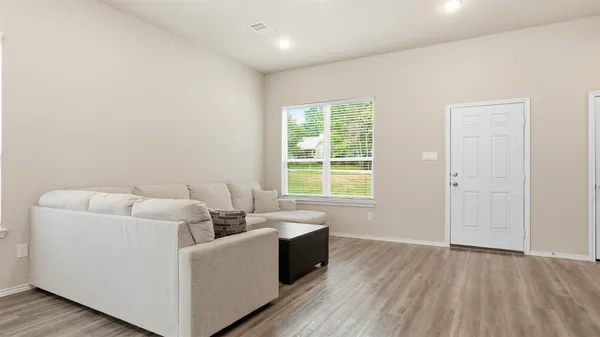 a living room with furniture and a wooden floor