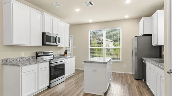 a kitchen with a stove a sink and a microwave