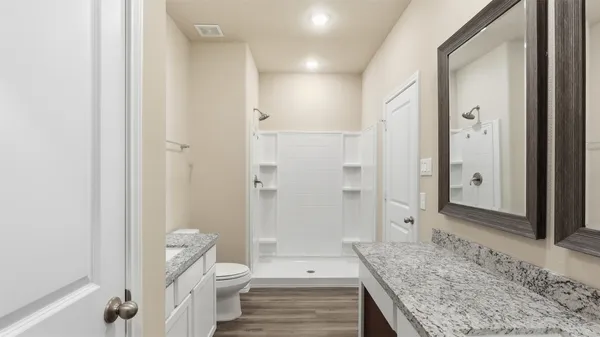 a bathroom with a granite countertop sink a toilet and shower