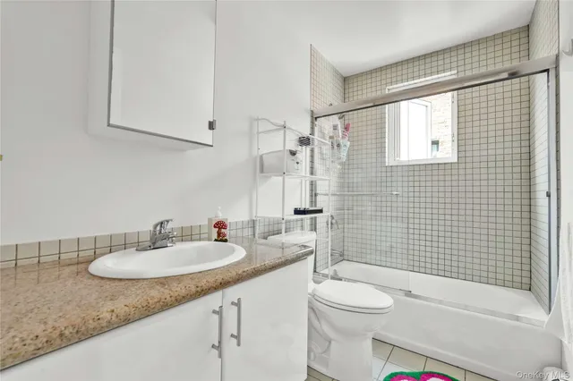 a bathroom with a granite countertop sink toilet mirror and shower
