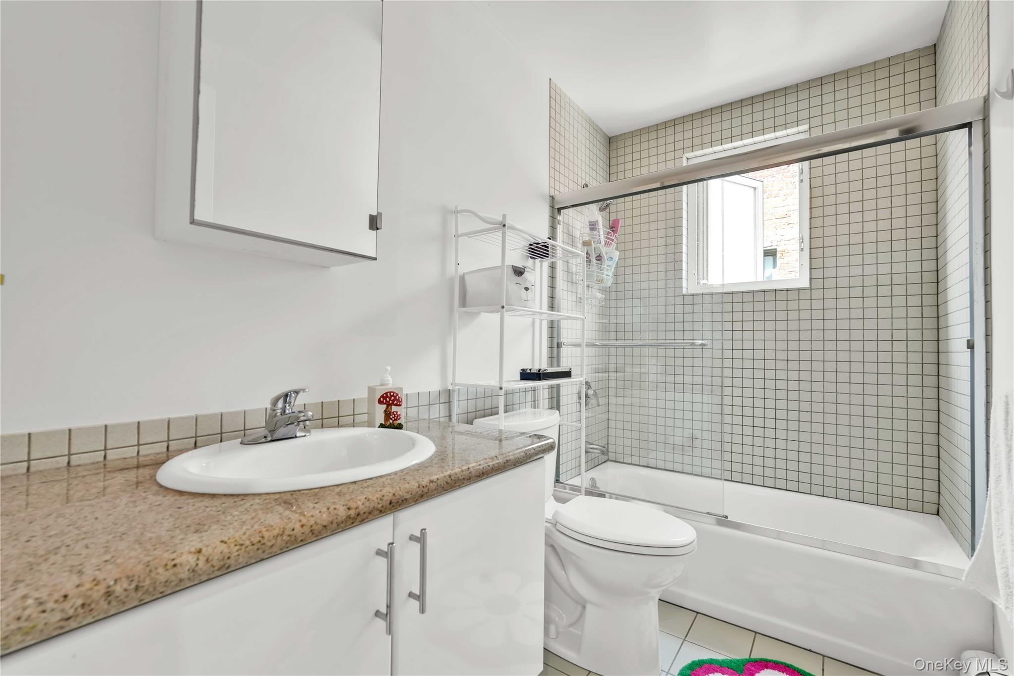 30-80 47th Street, Unit 3A Queens, NY 11103 - Photo 11 of 31 a bathroom with a granite countertop sink toilet mirror and shower