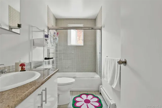 a bathroom with a granite countertop shower sink vanity mirror and toilet