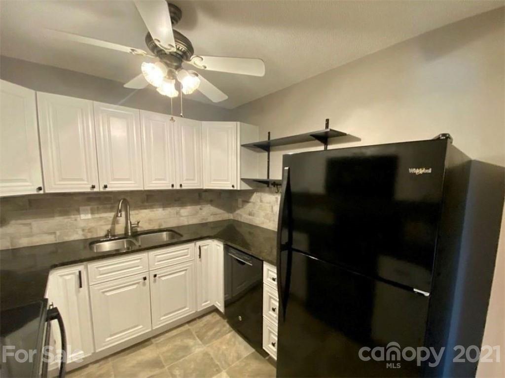 a kitchen with a sink dishwasher and a refrigerator