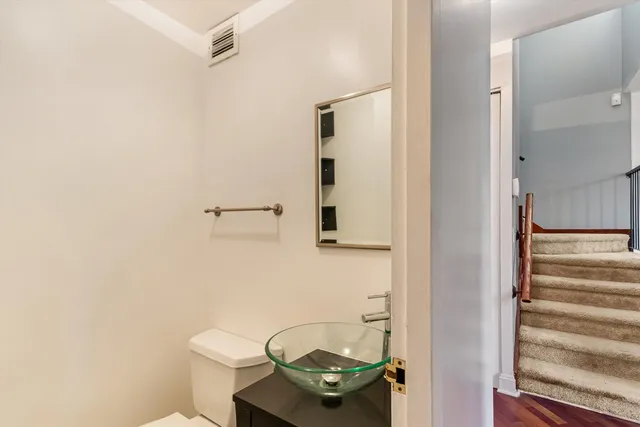 a bathroom with a toilet a sink and mirror