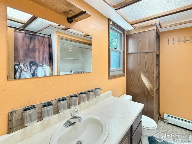 a bathroom with a sink toilet and mirror