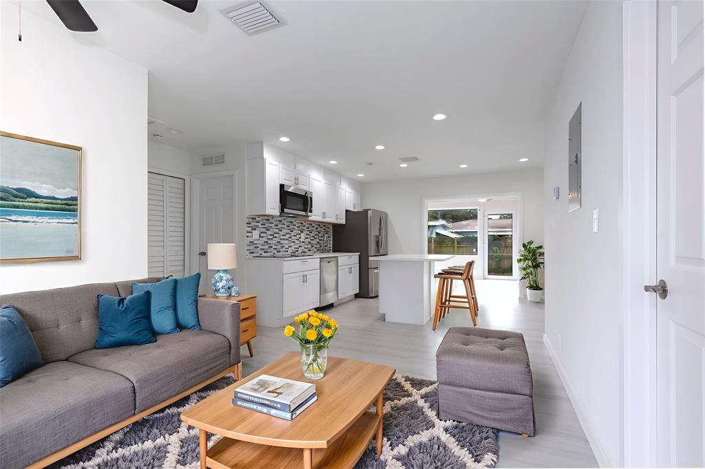 713 Southwest 4th Court Hallandale Beach, FL 33009 - Photo 1 of 38 a living room with furniture kitchen view and a wooden floor