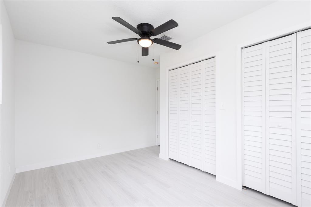 713 Southwest 4th Court Hallandale Beach, FL 33009 - Photo 12 of 38 an empty room with a ceiling fan and wooden floor